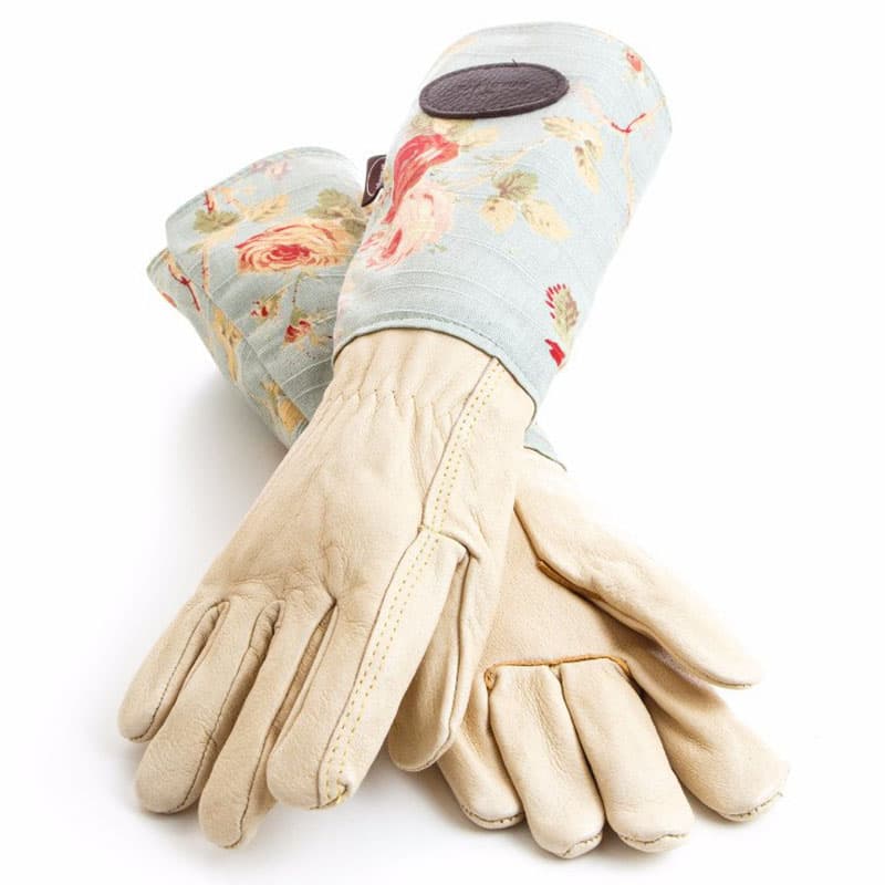 Skinnhandskar för trädgården med skyddande högt skaft i kraftigt vaxat linne med vackert rosmönster på blå bakgrund.